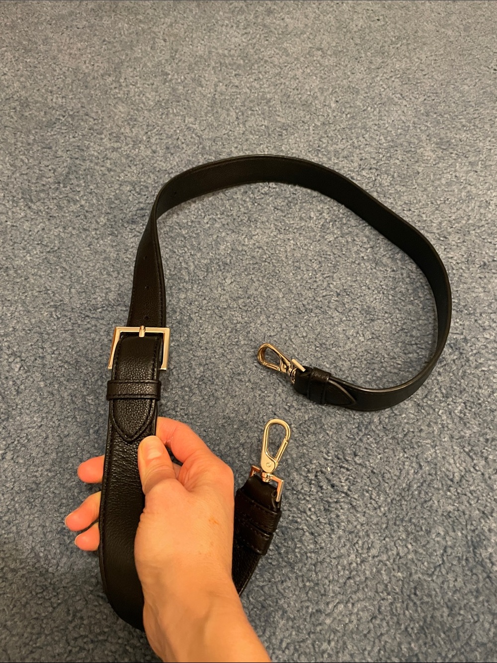 Black purse strap with gold hardware hooks & logo.